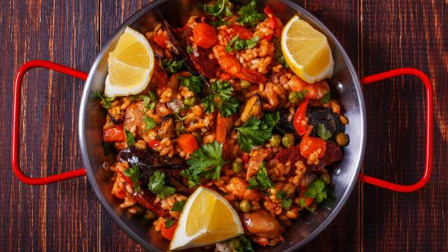 Paella with chicken, chorizo, seafood, vegetables and saffron.